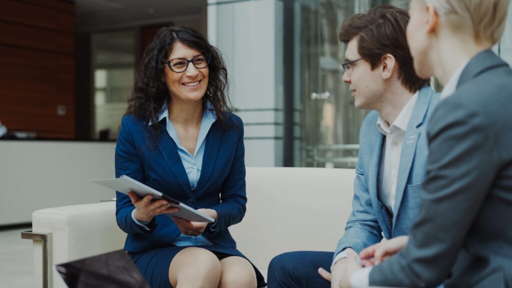woman in suit discussing specialized consulting niches with two men